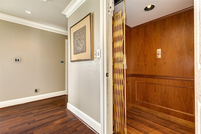 corridor featuring dark wood-style floors, baseboards, ornamental molding, and recessed lighting