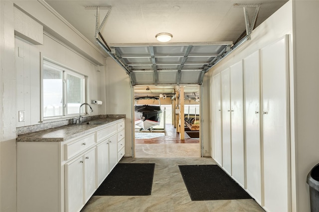 interior space with a sink and white cabinetry