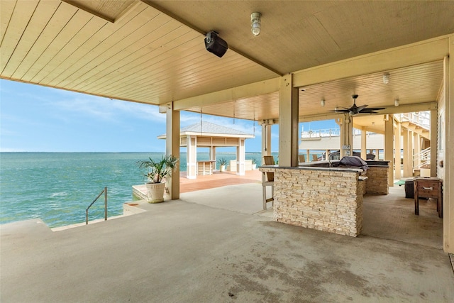 view of patio / terrace with a gazebo, exterior kitchen, and a water view