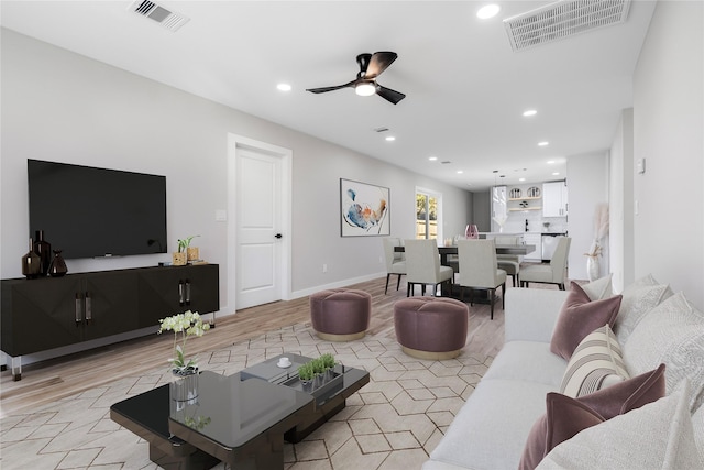 living area with a ceiling fan, recessed lighting, visible vents, and baseboards