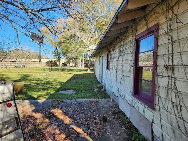 view of side of property with a yard and fence