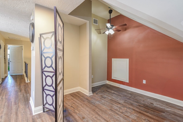 additional living space with a textured ceiling, dark wood-style flooring, visible vents, and baseboards