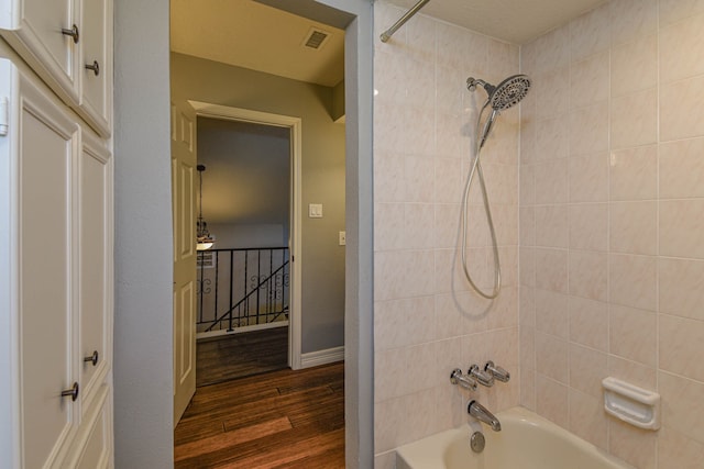 full bathroom featuring baseboards, visible vents, shower / washtub combination, and wood finished floors