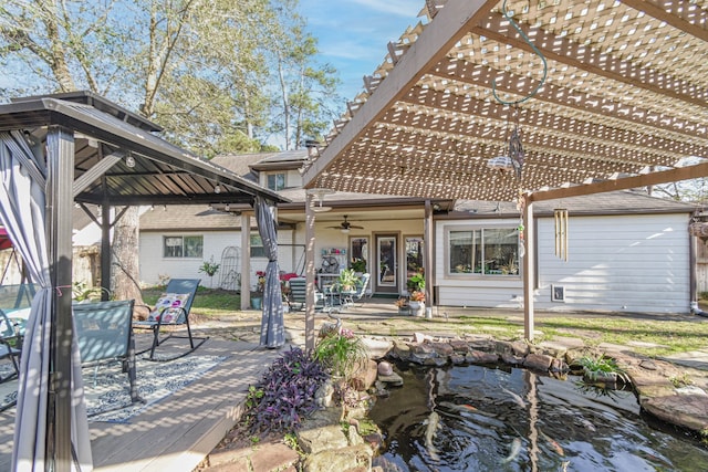 back of house featuring ceiling fan, a small pond, a pergola, and brick siding