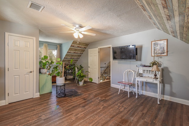 interior space with a ceiling fan, visible vents, vaulted ceiling, and wood finished floors