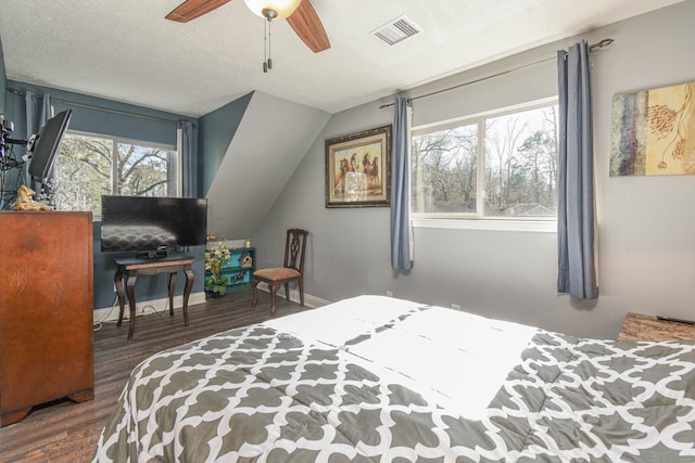 bedroom featuring lofted ceiling, visible vents, a textured ceiling, wood finished floors, and baseboards