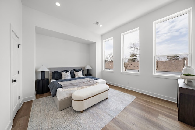 bedroom with recessed lighting, visible vents, baseboards, and wood finished floors