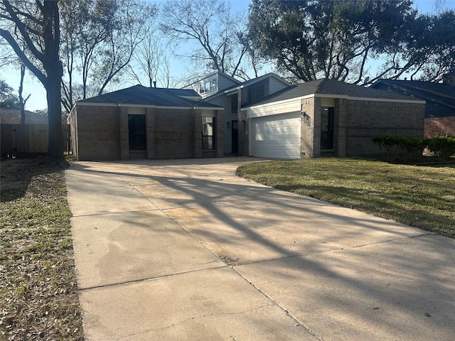 view of front of house featuring an attached garage, brick siding, concrete driveway, and a front yard