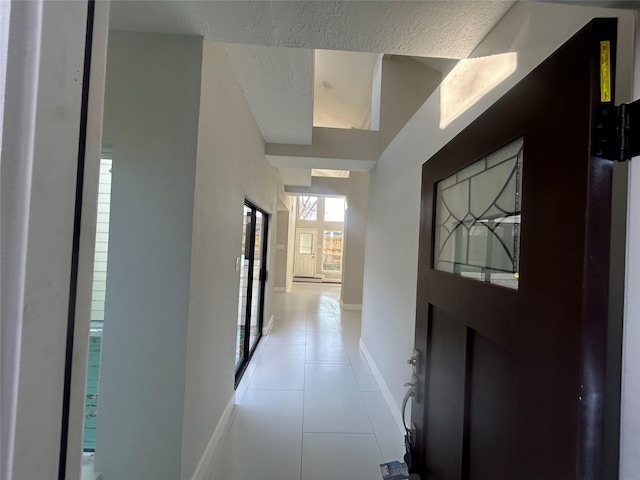 hallway with light tile patterned floors and baseboards