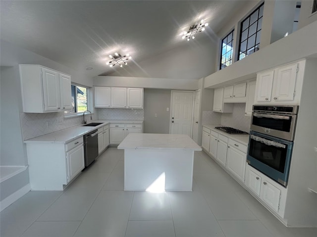 kitchen with stainless steel appliances, tasteful backsplash, a sink, and a center island