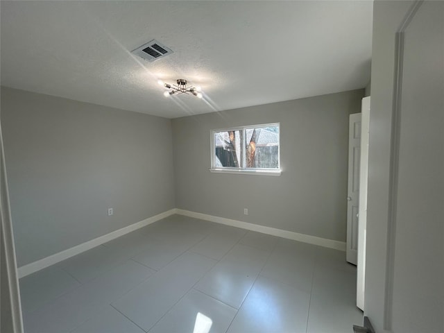 unfurnished bedroom featuring visible vents, a textured ceiling, and baseboards