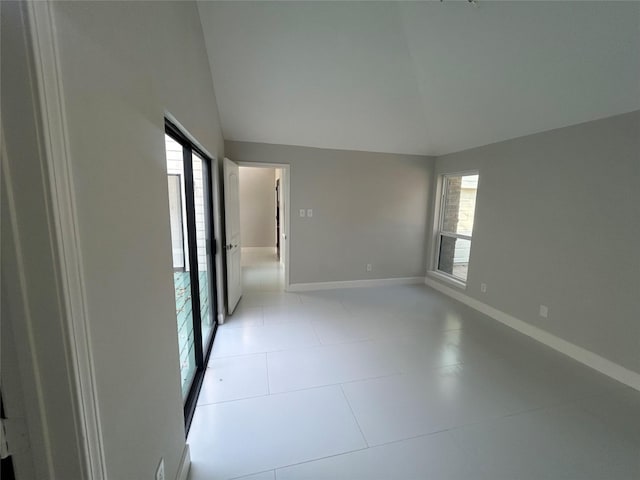 empty room with baseboards and vaulted ceiling