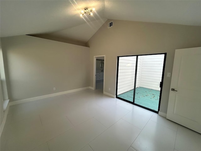 empty room with lofted ceiling, visible vents, and baseboards