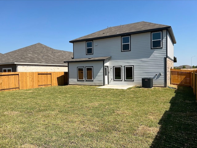 rear view of property with central AC unit, a lawn, a patio area, and a fenced backyard