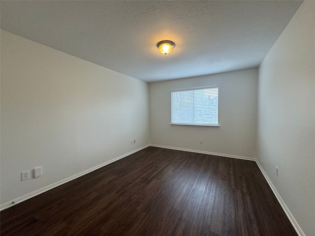 unfurnished room featuring a textured ceiling, baseboards, and dark wood-type flooring