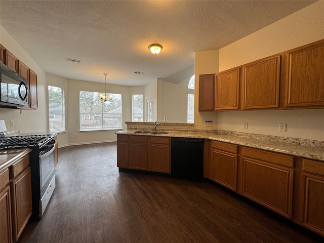 kitchen with dark wood-style floors, visible vents, brown cabinetry, a sink, and black appliances