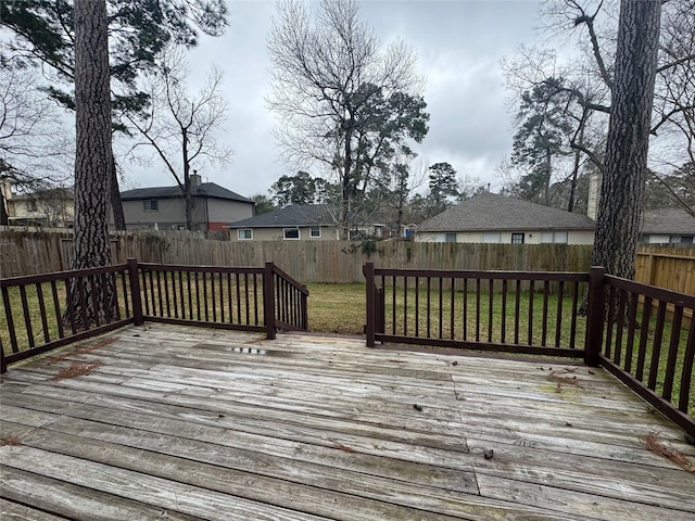 deck with a lawn and a fenced backyard