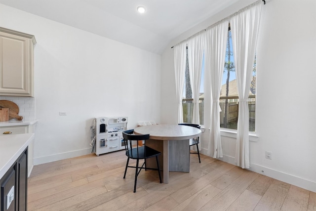 dining room with light wood-type flooring, vaulted ceiling, baseboards, and recessed lighting