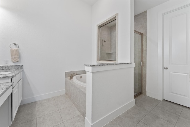 bathroom featuring tile patterned floors, a stall shower, vanity, baseboards, and a bath