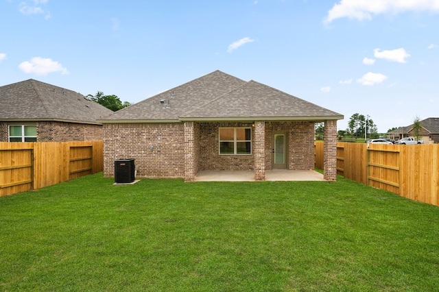 rear view of property with a patio area, a fenced backyard, a yard, and brick siding