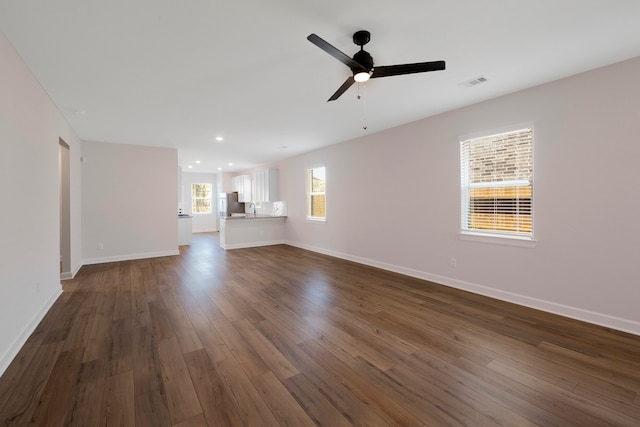 unfurnished living room with baseboards, visible vents, ceiling fan, dark wood-type flooring, and recessed lighting