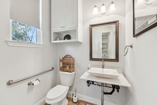 bathroom with toilet and baseboards