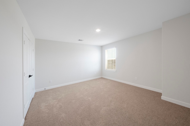 empty room featuring baseboards, recessed lighting, visible vents, and light colored carpet