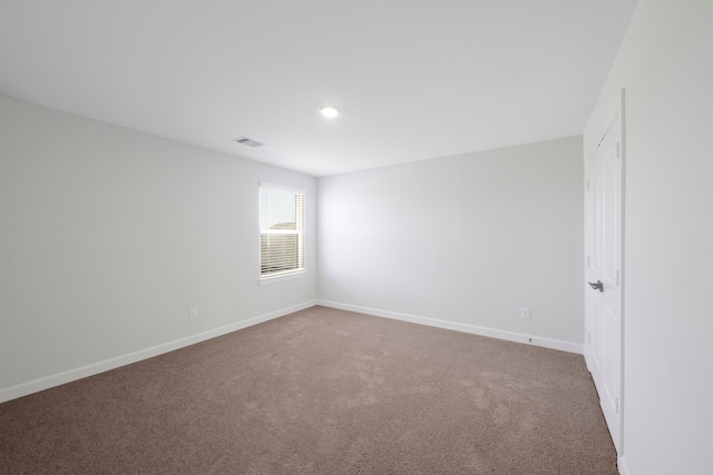 carpeted empty room featuring baseboards and visible vents