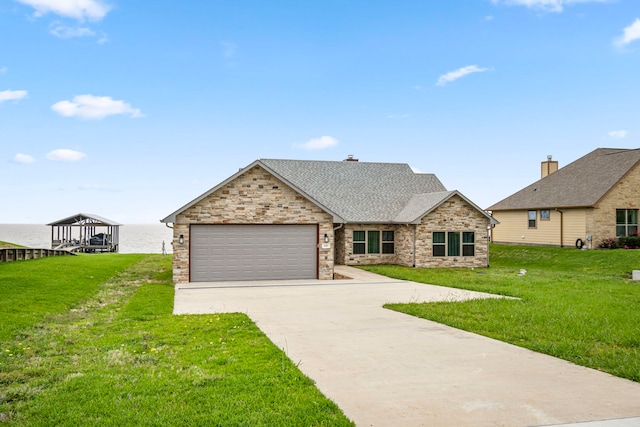 view of front facade featuring a garage, a front yard, concrete driveway, and roof with shingles