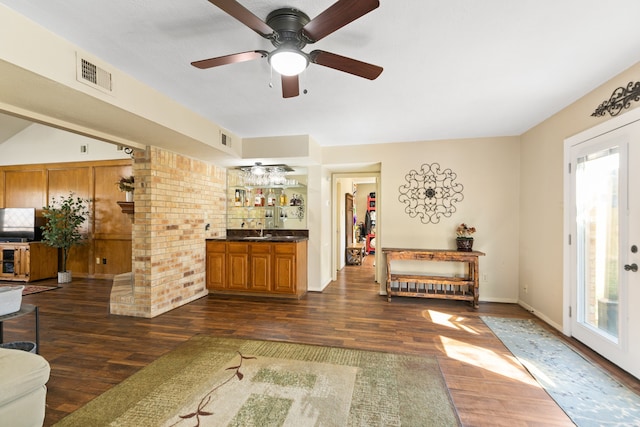 bar featuring a sink, dark wood-style floors, visible vents, and indoor wet bar