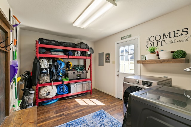 clothes washing area with a textured ceiling, wood finished floors, laundry area, electric panel, and independent washer and dryer