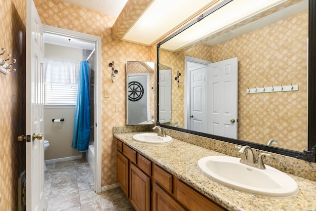 full bath featuring a sink, baseboards, and wallpapered walls