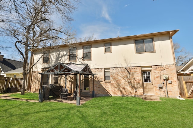 rear view of property featuring a yard, brick siding, and fence