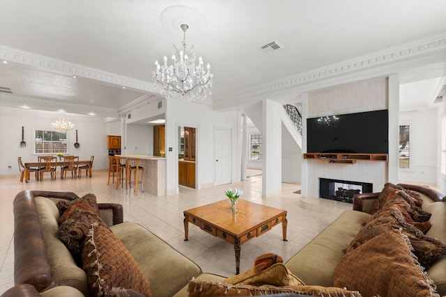 living room featuring visible vents, an inviting chandelier, crown molding, a fireplace, and light tile patterned flooring