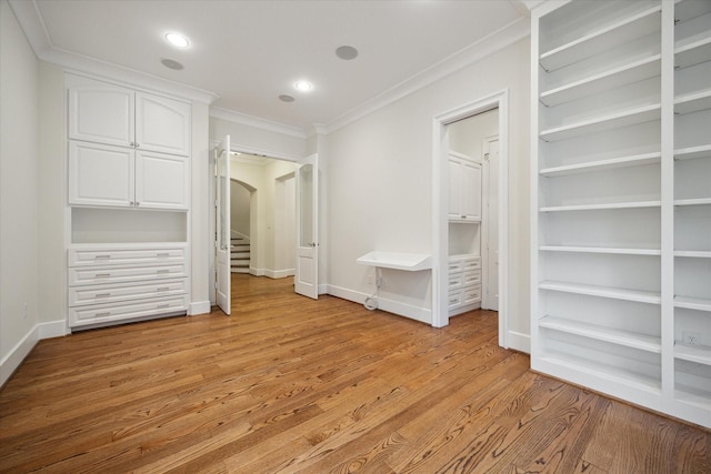 unfurnished bedroom with baseboards, arched walkways, ornamental molding, light wood-type flooring, and recessed lighting