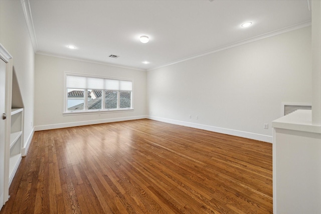 spare room with crown molding, recessed lighting, visible vents, wood finished floors, and baseboards