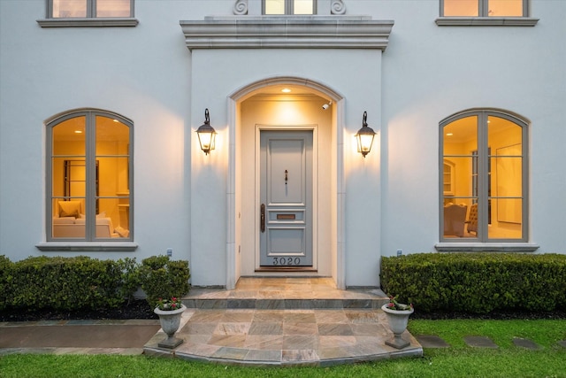 entrance to property featuring stucco siding