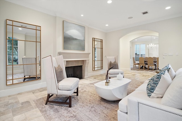 living area featuring arched walkways, a fireplace, baseboards, and recessed lighting