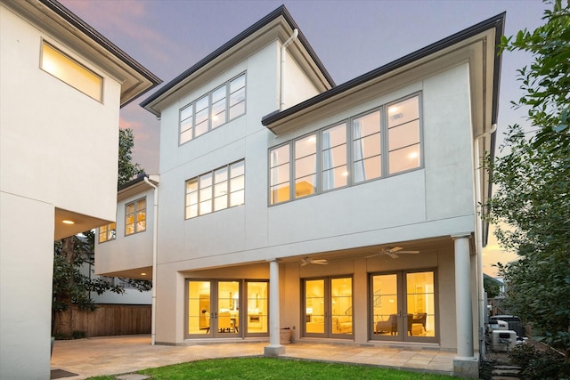 rear view of house with ceiling fan, a patio area, fence, and stucco siding