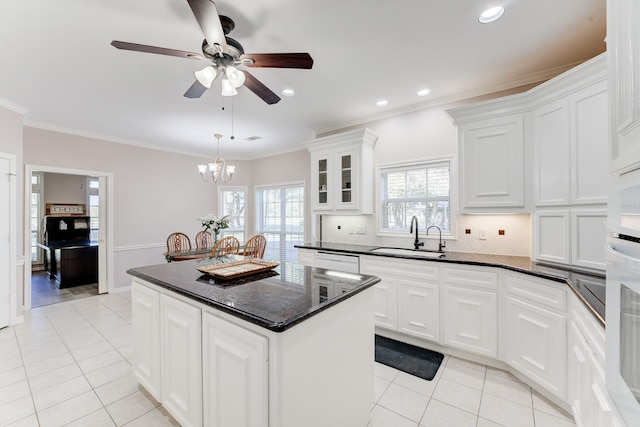 kitchen featuring decorative backsplash, white cabinets, a kitchen island, a sink, and light tile patterned flooring