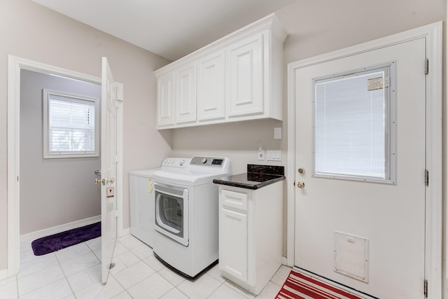 laundry area featuring independent washer and dryer, light tile patterned flooring, cabinet space, and baseboards