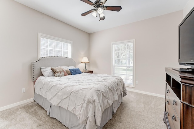 bedroom with light colored carpet, baseboards, and multiple windows