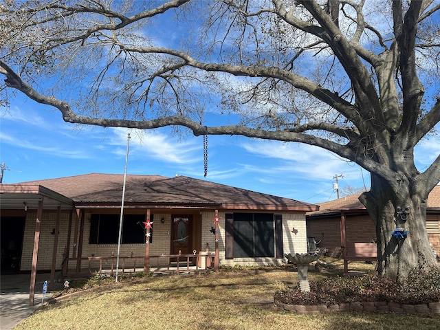 ranch-style home featuring a garage, brick siding, a porch, and roof with shingles