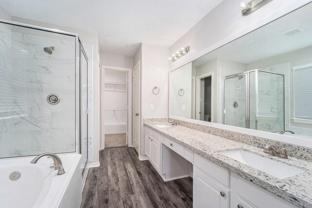 1911 Arrow Star Ct, Katy, TX 77493 - full bathroom featuring a shower stall, wood finished floors, double vanity, a spacious closet, and a bath