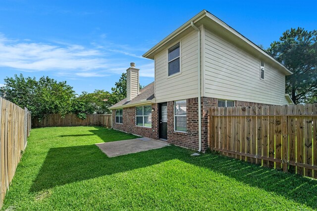 1911 Arrow Star Ct, Katy, TX 77493 - back of house featuring brick siding, a fenced backyard, a chimney, and a patio
