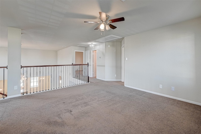 carpeted empty room with attic access and baseboards