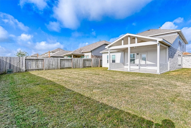 back of property featuring a patio, a yard, and a fenced backyard