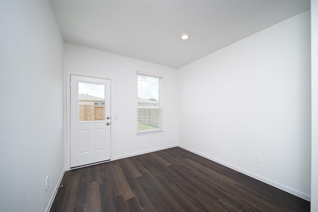 spare room with baseboards, dark wood finished floors, and recessed lighting