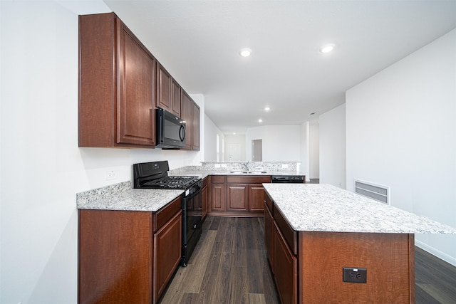 kitchen featuring a center island, dark wood-type flooring, a sink, a peninsula, and black appliances