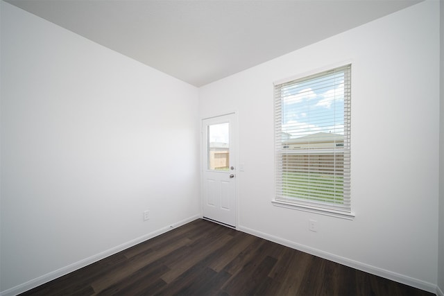 unfurnished room featuring dark wood-type flooring and baseboards